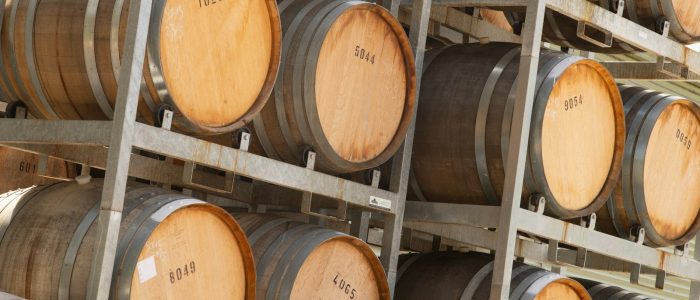 Photo by Geoff Brooks a bunch of wooden barrels stacked on top of each other