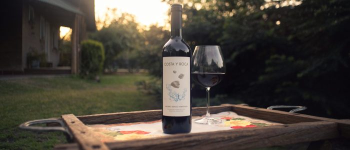 Photo by Mario Amé a bottle of wine sitting on top of a wooden tray